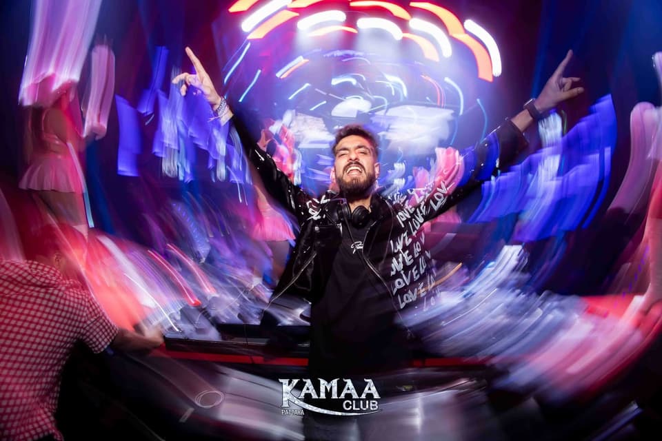 DJ with arms outstretched in a whirl of light at Kamaa Club Pattaya