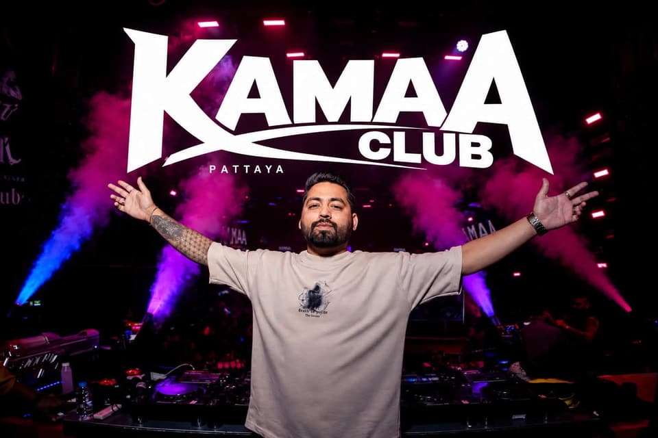 Host with arms wide in front of the giant Kamaa Club logo at Kamaa Club Pattaya