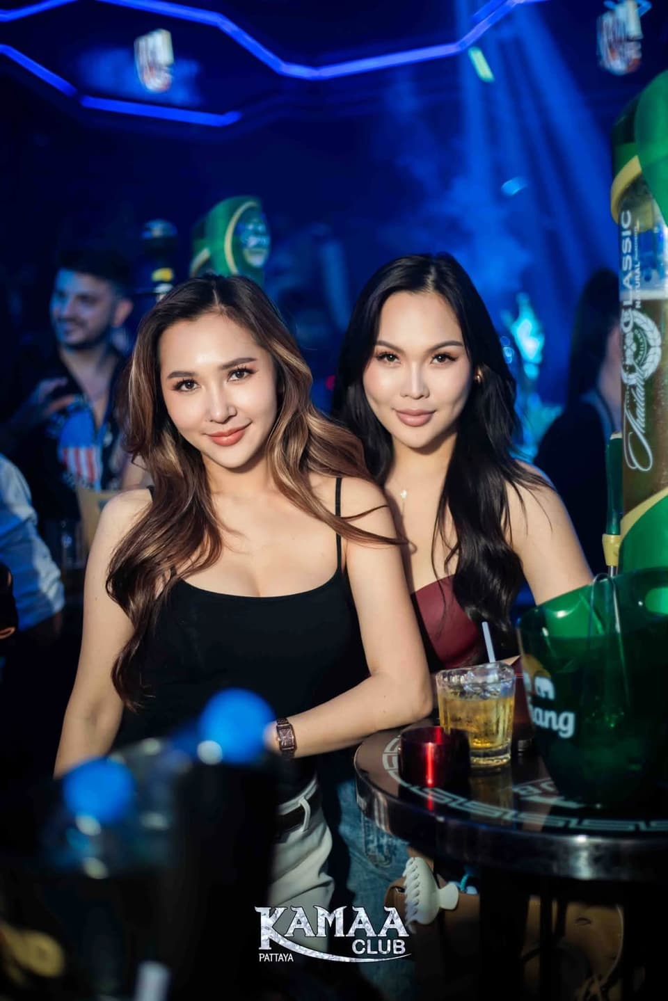 Two friends at a table under blue lights at Kamaa Club Pattaya