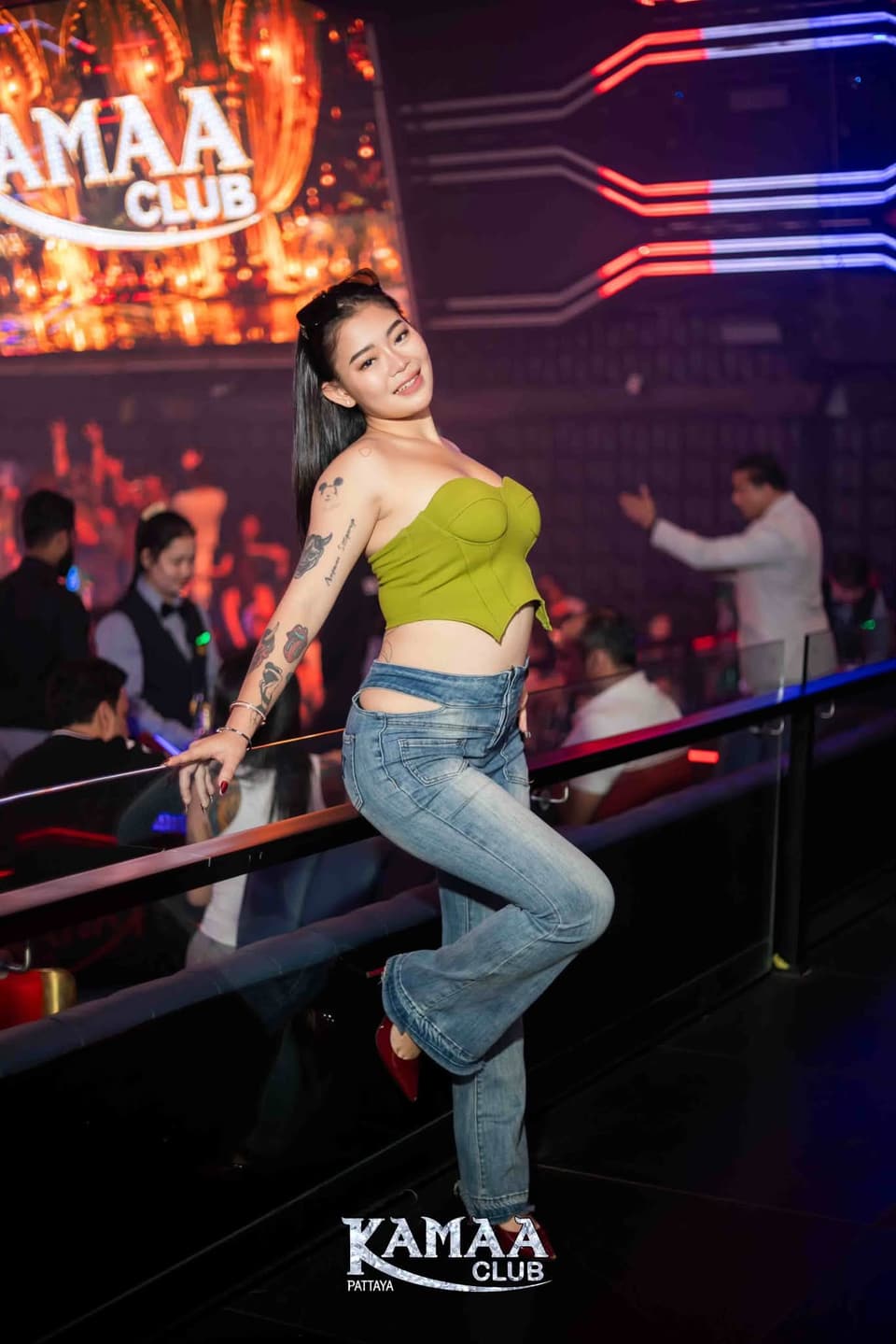 Guest in jeans and a lime top on the upper level at Kamaa Club Pattaya