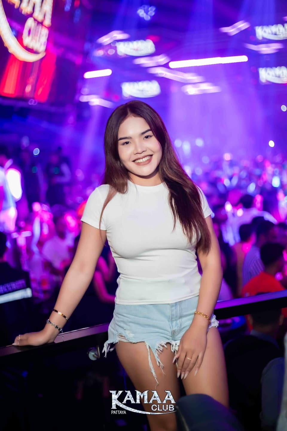 Guest in a white T-shirt smiling under purple lights at Kamaa Club Pattaya
