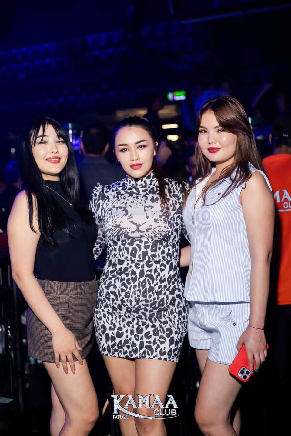 Three friends posing together under blue lights at Kamaa Club Pattaya