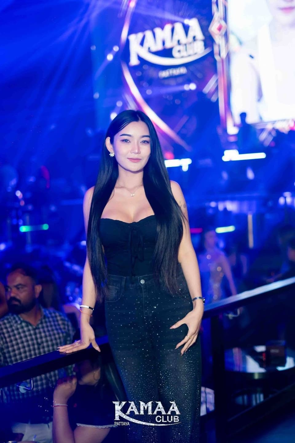 Guest in a black dress under blue lights and the Kamaa logo at Kamaa Club Pattaya